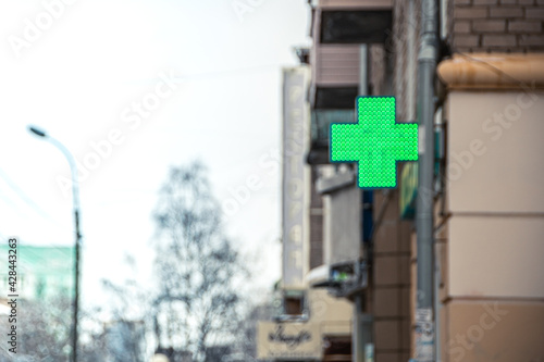 Green pharmacy cross on corner of building