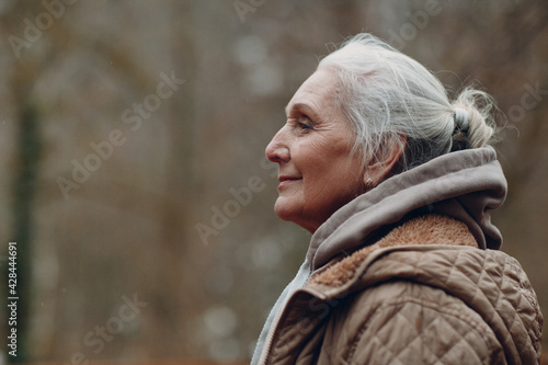 Portrait profile of smiling gray haired elderly woman outdoor