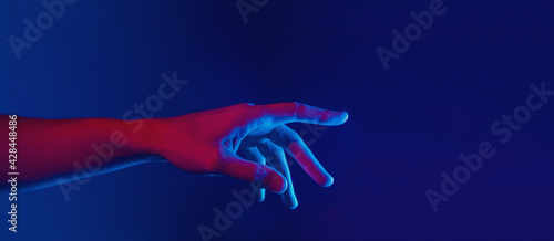 male hand touching or pointing in neon red blue lighting, web banner