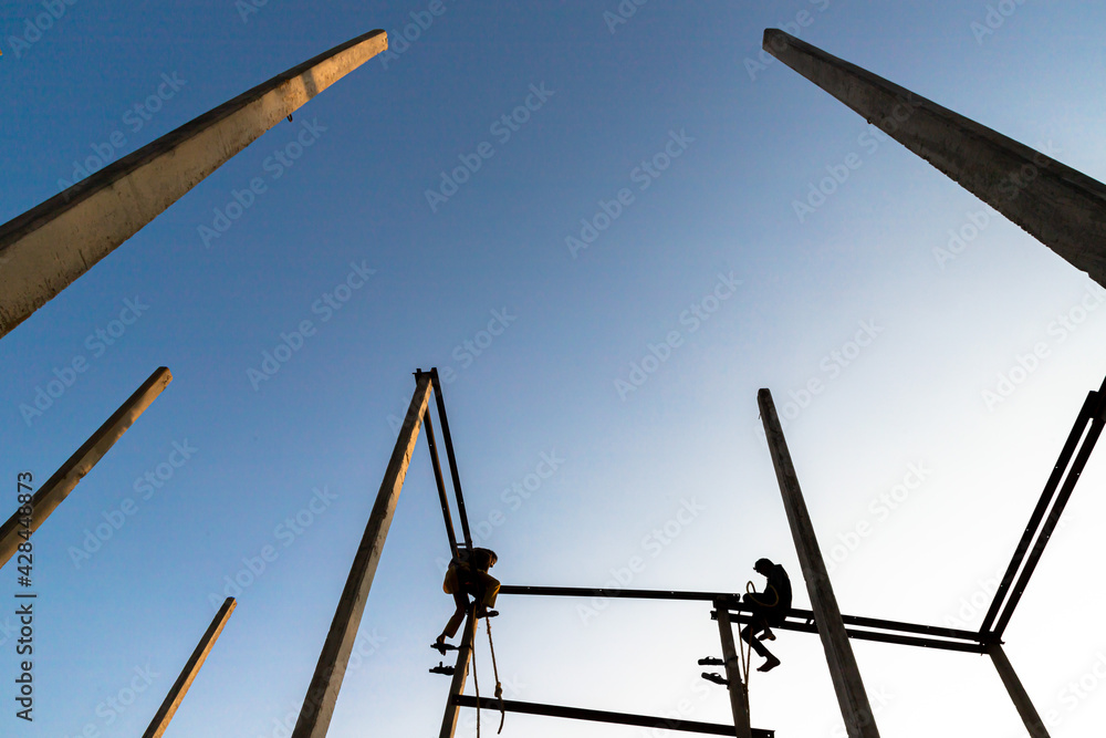 Fototapeta premium silhouette of a man sitting on electric pole.