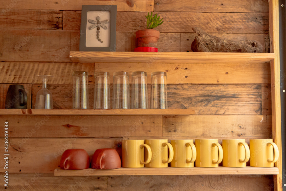 repisas con vasos y tazas sobre pared de madera foto de Stock