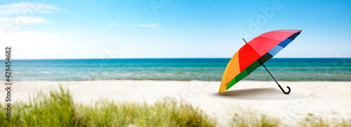 Bunter Sonnenschirm am Strand am Meer