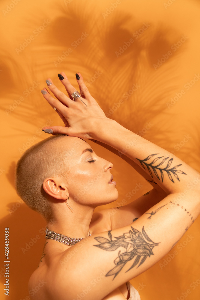 Fototapeta premium Woman with jewelry posing fashionably with closed eyes and hands near her head