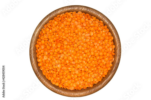 Red lentils in wooden bowl. Isolated on white background. Healthy and organic food