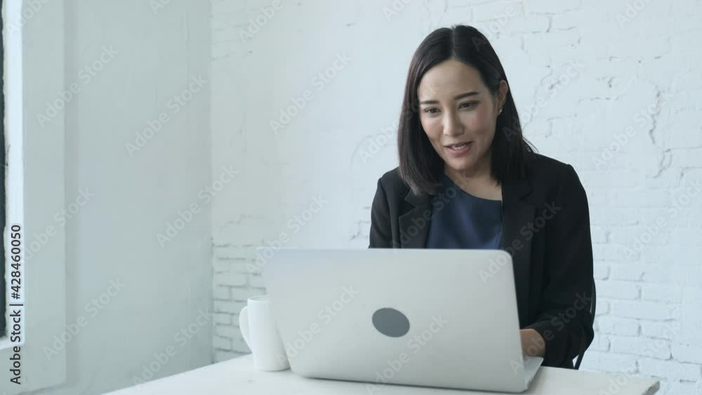 Young business woman is happily using a laptop to work in a coffee shop. Young business woman is happily using a laptop to work in a coffee shop.