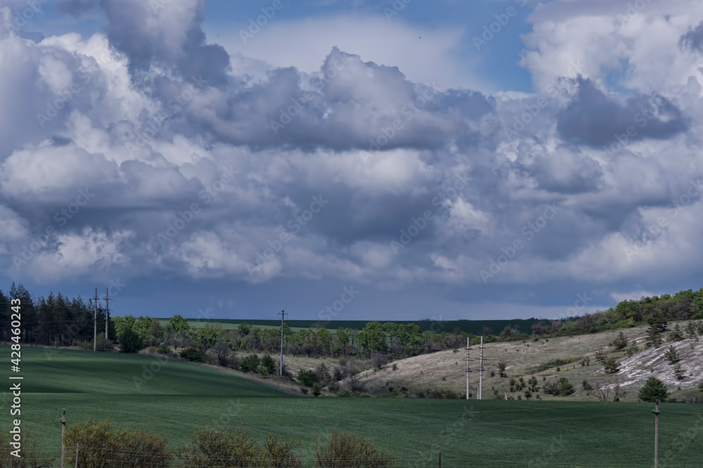 Field, hills and and plains, dramatic cloudy sky