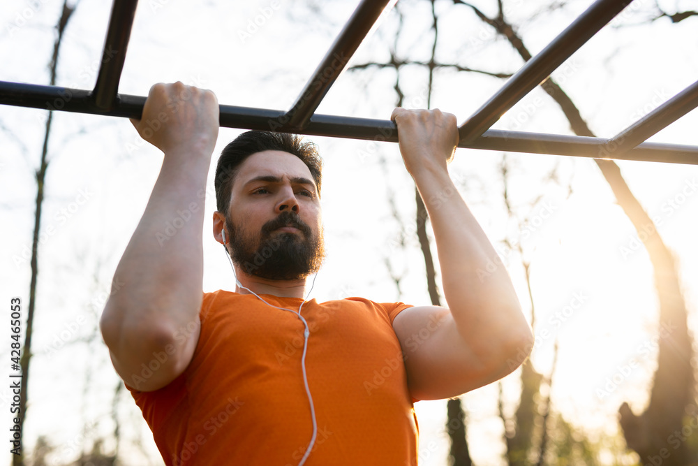 Naklejka premium The handsome young man is working out in nature