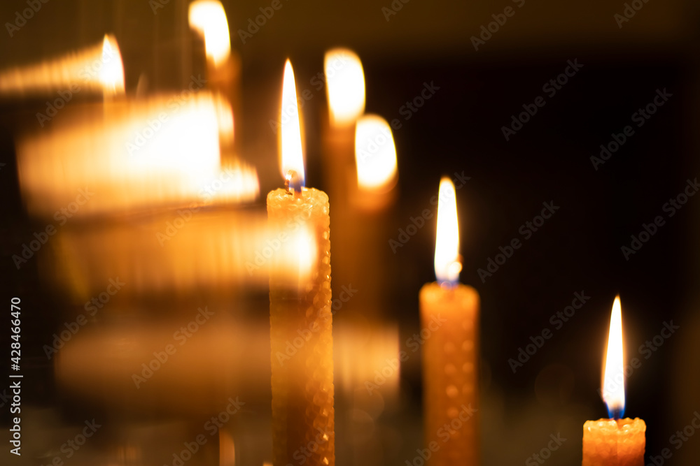 Wax lighted candles in the dark. Candle lights. Beautiful bokeh in the background.