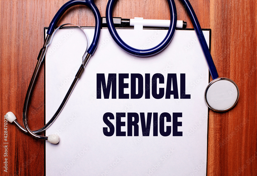 On a wooden background lies a stethoscope and a sheet of paper with the inscription MEDICAL SERVICE. Flat lay. Medical concept On a wooden background lies a stethoscope and a sheet of paper with the inscription MEDICAL SERVICE. Flat lay. Medical concept