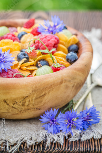 Healthy and slimming breakfast. Flowers and fruits with cornflakes.