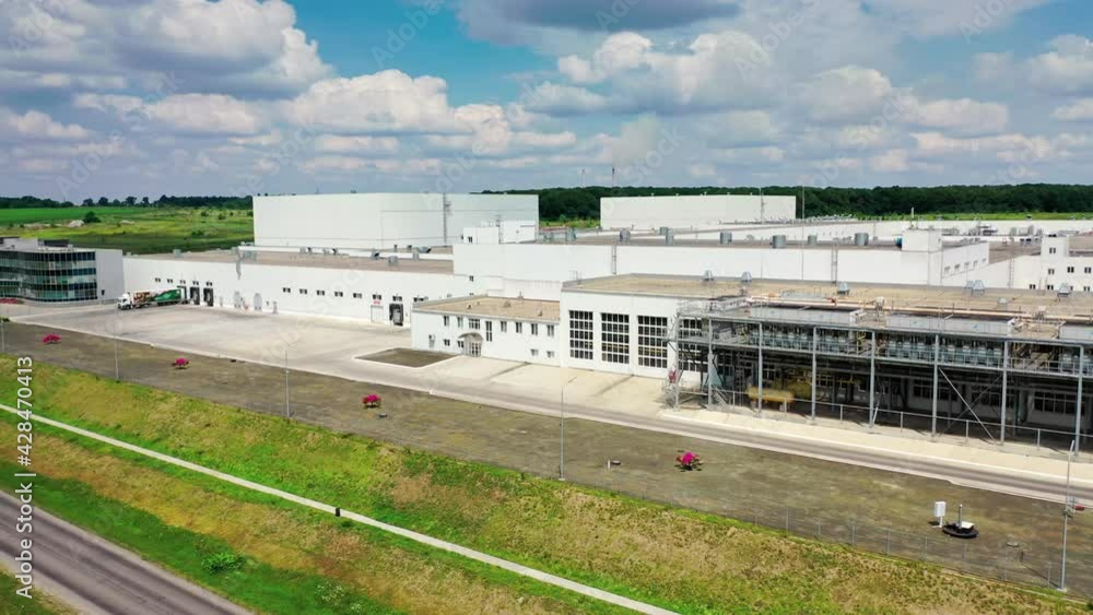 Contemporary industrial plant near the highway. White buildings of innovative factory on green nature background. Top down. Contemporary industrial plant near the highway. White buildings of innovative factory on green nature background. Top down.