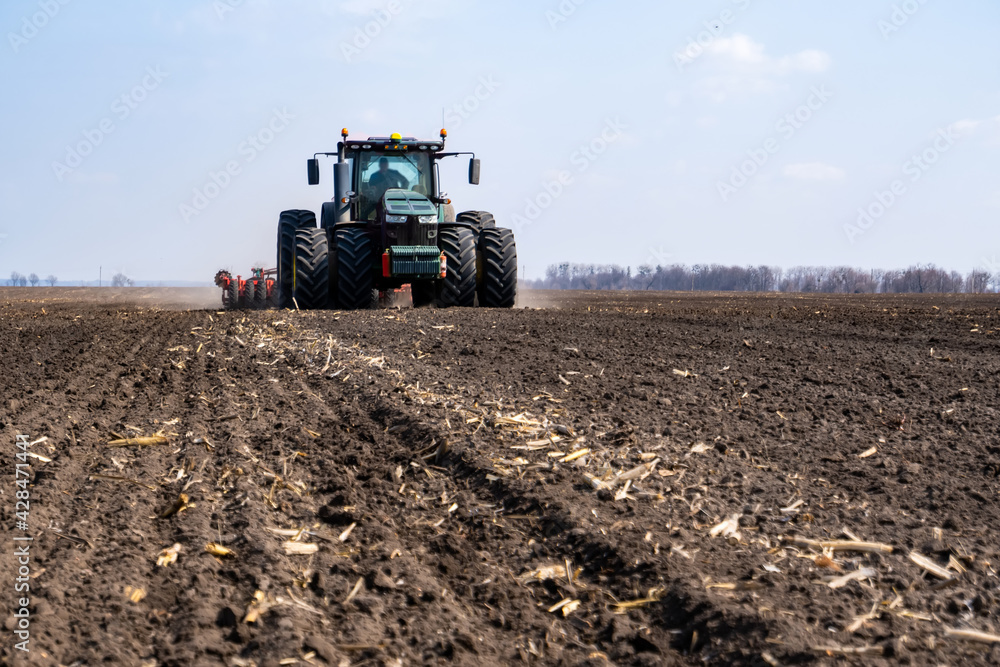 tractor with seeder in the field in early spring tractor with seeder in the field in early spring