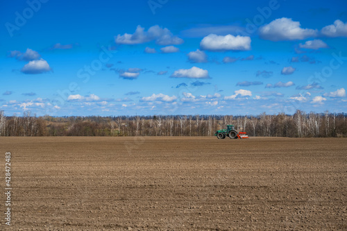 tractor with seeder in the field in early spring