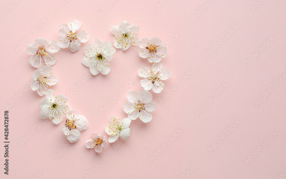 Delicate apricot flowers light in shape of heart on pink background, pastel and soft card Delicate apricot flowers light in shape of heart on pink background, pastel and soft card