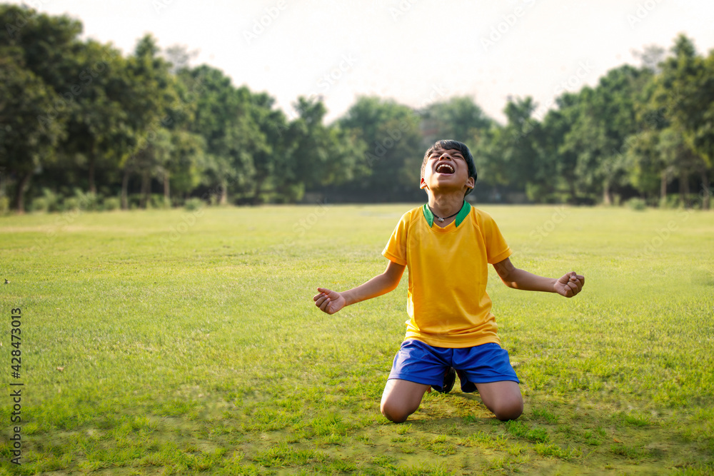 Full Length of Excited boy football player after goal scored Full Length of Excited boy football player after goal scored