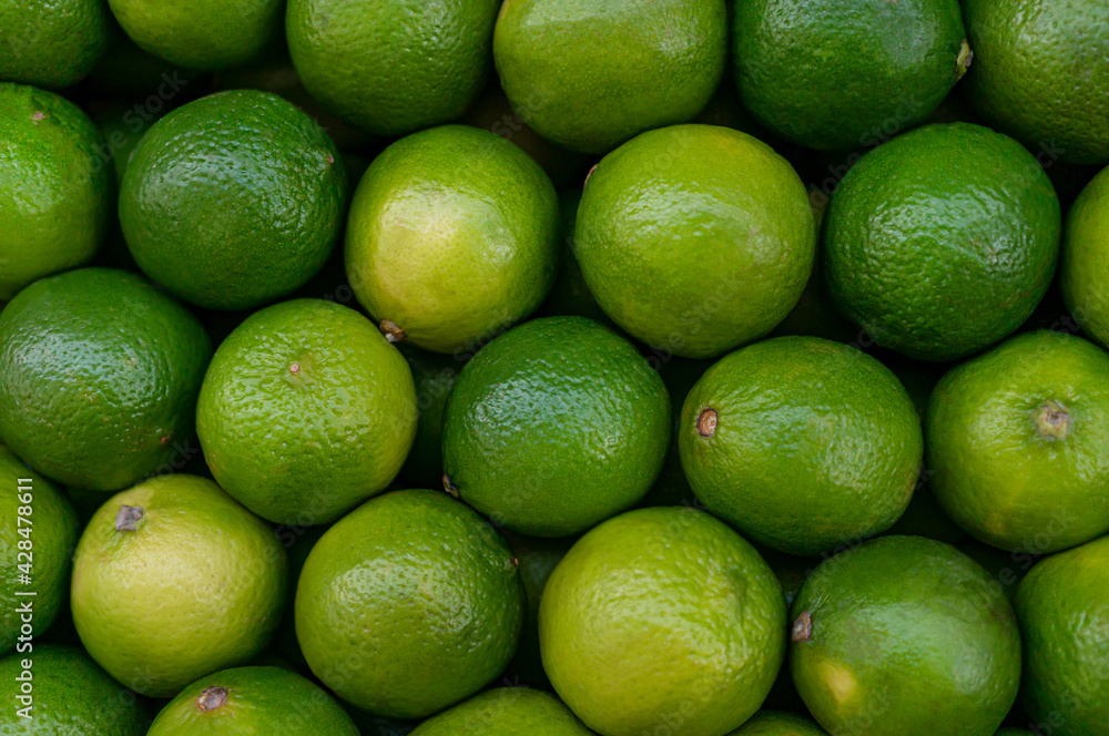 Lime citrus fruits in the fruit market. Texture juicy green tropical lime fruit. Image green limes Lime citrus fruits in the fruit market. Texture juicy green tropical lime fruit. Image green limes