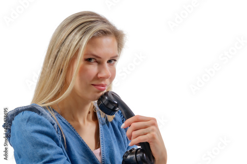 Young beautiful woman holds the receiver of a vintage landline telephone. Isolation on a white background