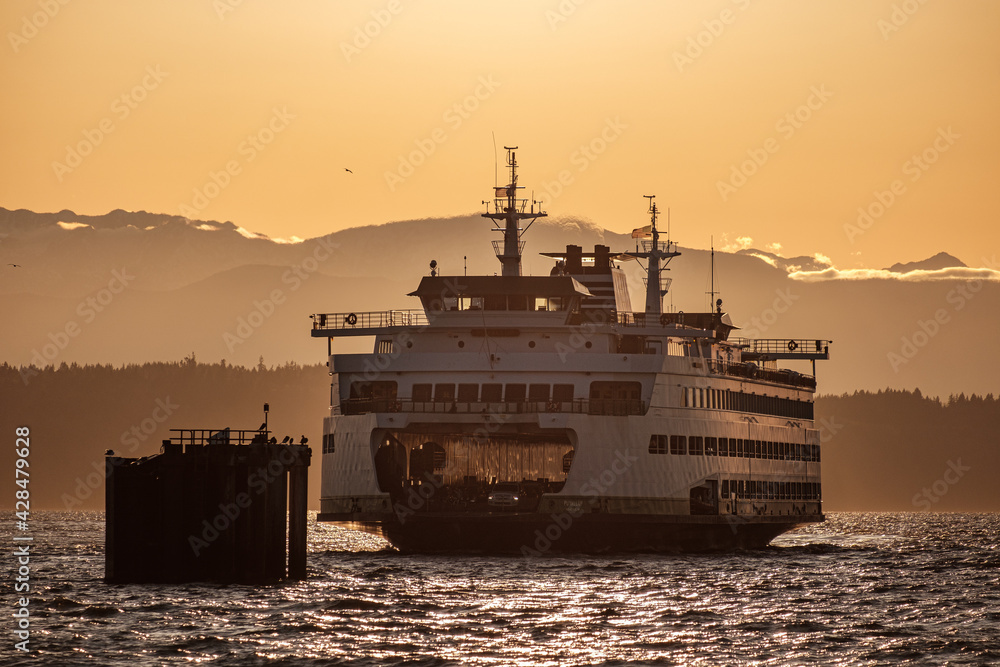 A ferry boat comes in to dock during the last hours of sunset