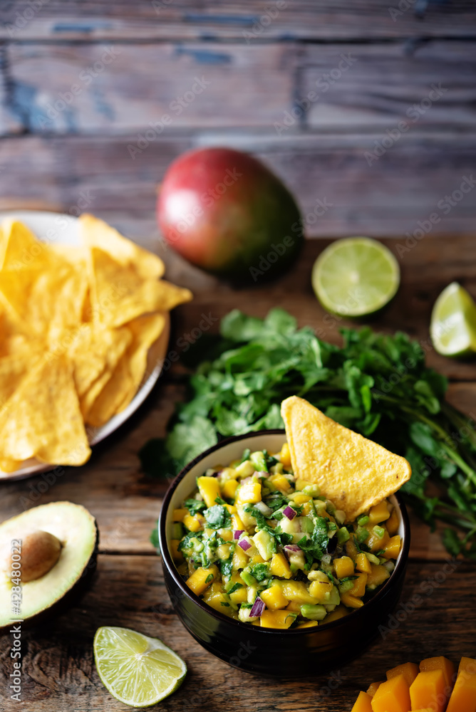 Mango Guacamole with corn chips and ingredients to prepare it Mango Guacamole with corn chips and ingredients to prepare it