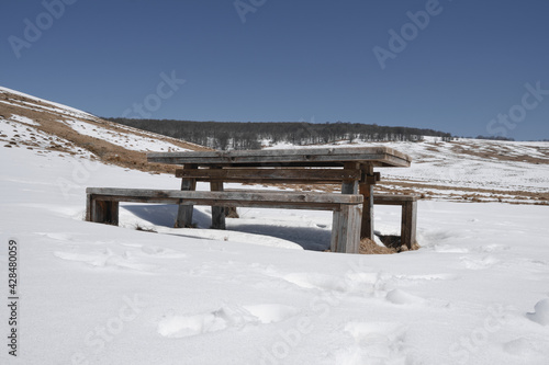 Wallpaper Mural Wooden bench and table in the middle of snow covered highland under a clear blue sky during winter Torontodigital.ca
