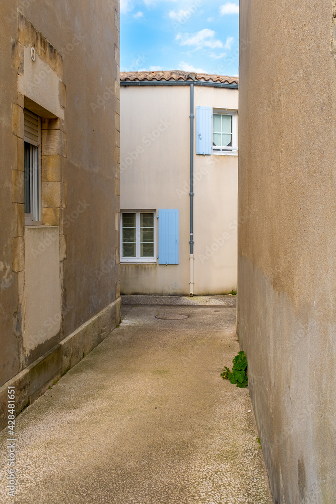 One small empty narrow street in the old town of Saint-Trojan-les-Bains, France
