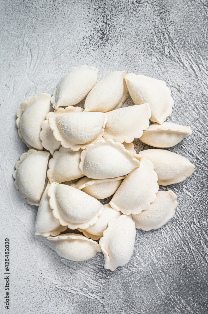 Raw frozen dumplings pierogi on a kitchen table. White background. Top View