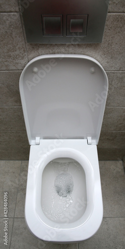 Fotografía A new white toilet when driving water