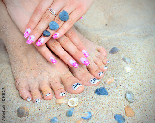Manicure and pedicure against the background of sea sand and seashells. Selective focus. Manicure and pedicure images over sand beach background