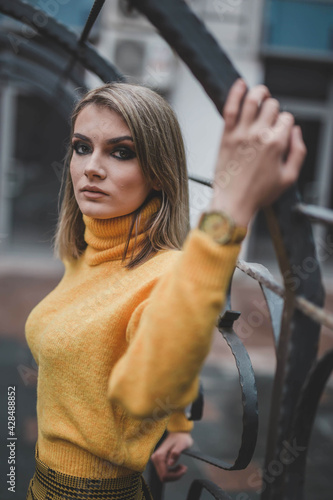 Closeup of a stylish Bosnian female wearing a rollneck sweater is posing outside photo