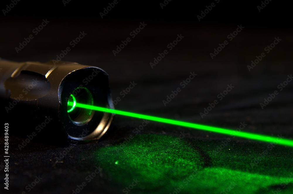 Potente puntatore laser con fascio verde. Stock Photo