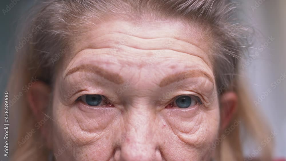 Close up on blue eyes of an elderly woman with wrinkled skin. Depression at old age. High quality 4k footage Close up on blue eyes of an elderly woman with wrinkled skin. Depression at old age. High quality 4k footage