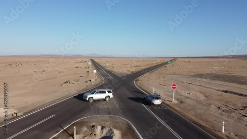 Cars on Crossroad in the Desert of Atacama, Fork Junction where the Road is Splitted in Two Fifferent Ways, Atacama Desert, Chile, South America. Drone View.  photo