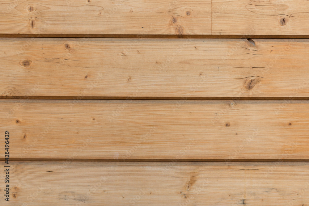 Naklejka premium The facade of the house is made of new horizontal wooden boards. Wooden texture