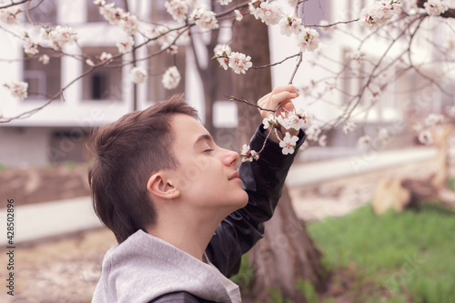 Portrait of a teenager with flowering branches. Springtime.