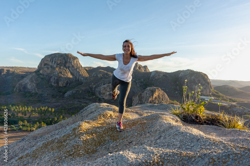 Mulher jovem no topo da montanha de braços abertos para o mundo com felicidade