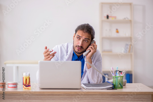 Young male odontologist in telemedicine concept