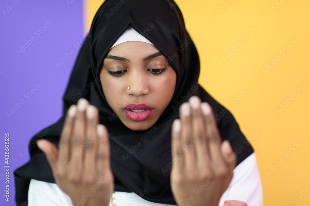 african muslim woman wearing hijab and traditional muslim clothes posing in front of green background african muslim woman wearing hijab and traditional muslim clothes posing in front of green background