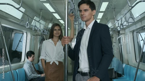 Young businessman greets a girl on the electric train when returning from work.