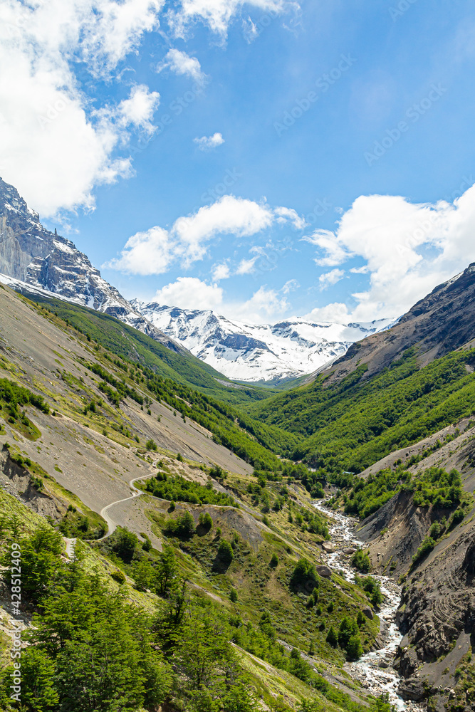 trilhas do circuito w no vale da Ascensão, com rio ao fundo montanhas com florestas verdes e ao fundo as montanhas dos Andes 