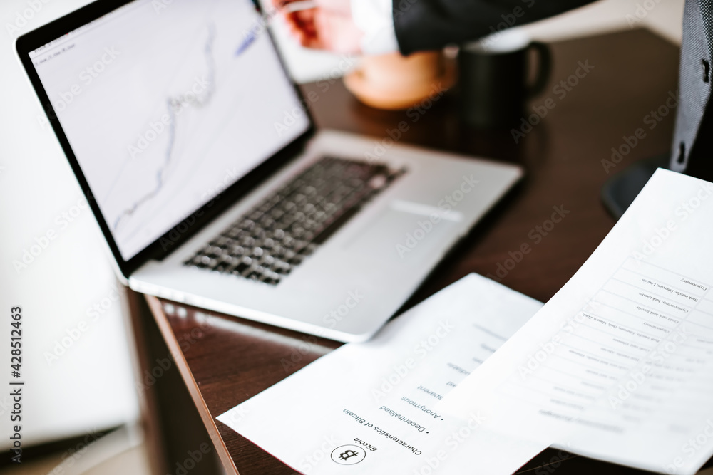 stocks price rising graph data trend laptop screen. Investment manager desk with with green plant and cup of coffee stocks price rising graph data trend laptop screen. Investment manager desk with with green plant and cup of coffee