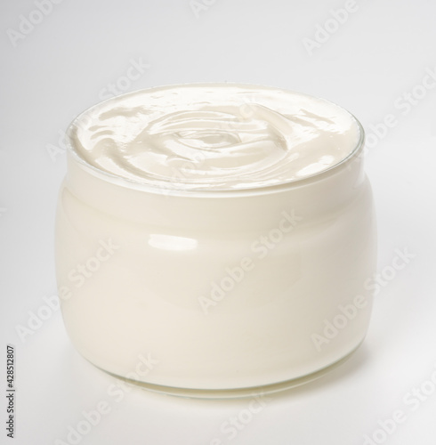 Sour cream in glass jar isolated on white background