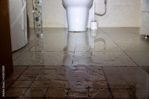 Water damage due a broken pipe or toilet. Moisture problem and wet floor. Horizontal, selective focus