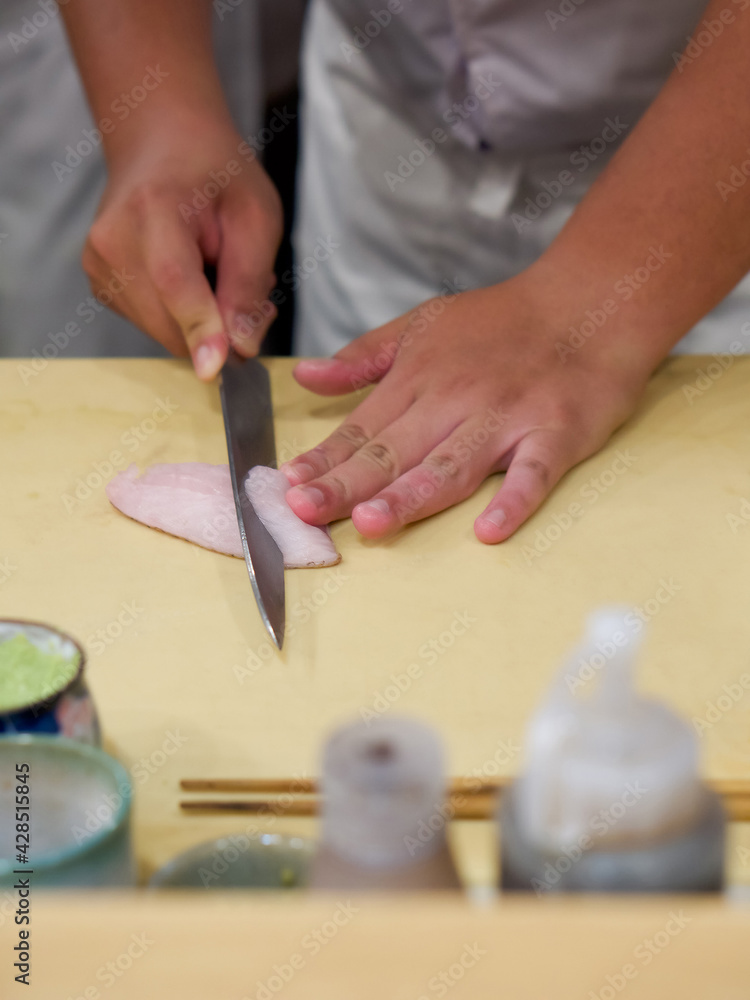 Chef use sharp knife slicing Aburi white fish for sashimi. Enjoy Omakase experience at Japanese Sushi Restaurant. Chef use sharp knife slicing Aburi white fish for sashimi. Enjoy Omakase experience at Japanese Sushi Restaurant.
