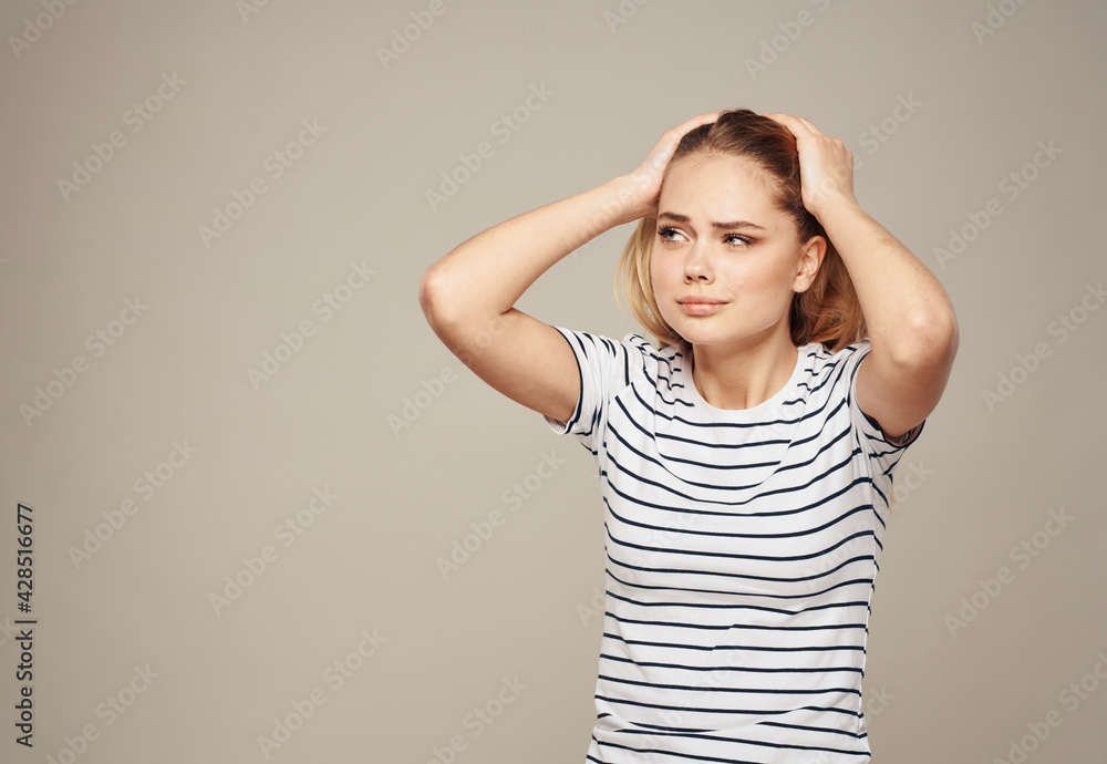 Portrait of woman on beige background gesturing with hands cropped view of striped t-shirt Portrait of woman on beige background gesturing with hands cropped view of striped t-shirt