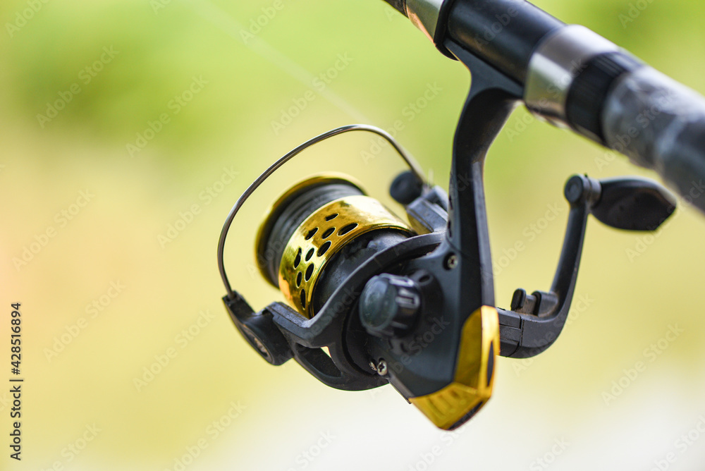 Obraz premium Fishing reel on Fishing rod, Fishing on the feeder with nature background