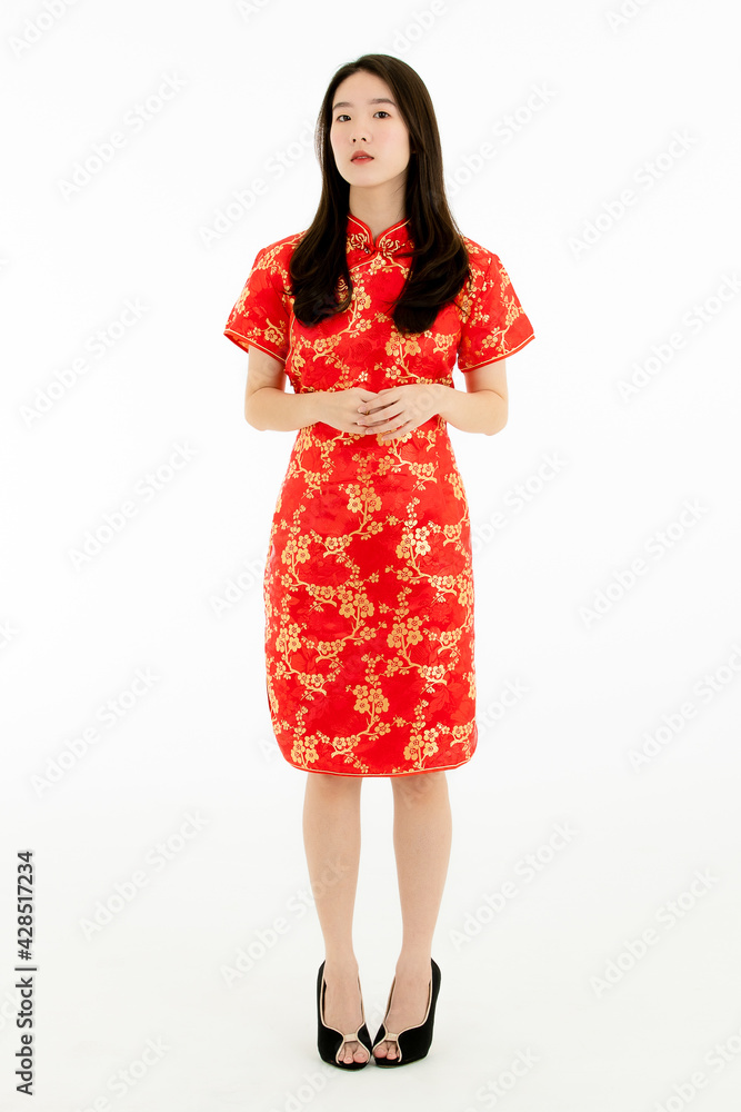 Full body shot of Chinese beautiful woman with long black hairs is standing, smiling against white background. She wearing red traditional dress that has pattern of gold flower. Full body shot of Chinese beautiful woman with long black hairs is standing, smiling against white background. She wearing red traditional dress that has pattern of gold flower.