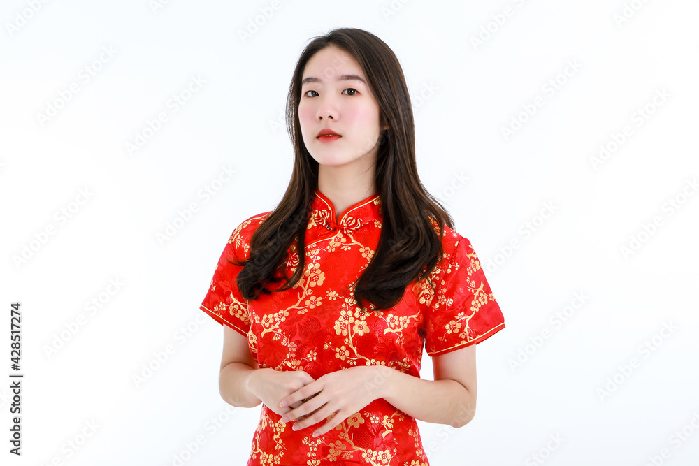 Half body shot of Chinese beautiful woman with long black hairs is standing, smiling against white background. She wearing red traditional dress that has pattern of gold flower. Half body shot of Chinese beautiful woman with long black hairs is standing, smiling against white background. She wearing red traditional dress that has pattern of gold flower.