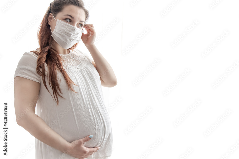 Young pregnant woman in protective medical mask copy space. Young pregnant woman in protective medical mask copy space.