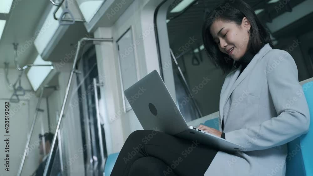 Businesswomen discussing work from their laptops on the electric train in the middle of the night. Businesswomen discussing work from their laptops on the electric train in the middle of the night.