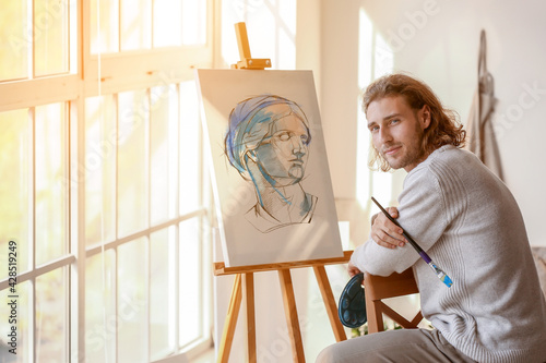 Young male artist painting ...